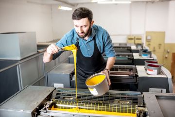 Drucker füllt gelbe Farbe in die Druckmaschine